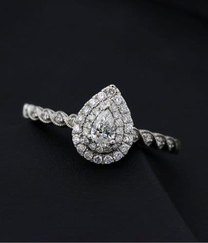 Pear-shaped diamond engagement ring with a double halo and twisted pavé diamond band.