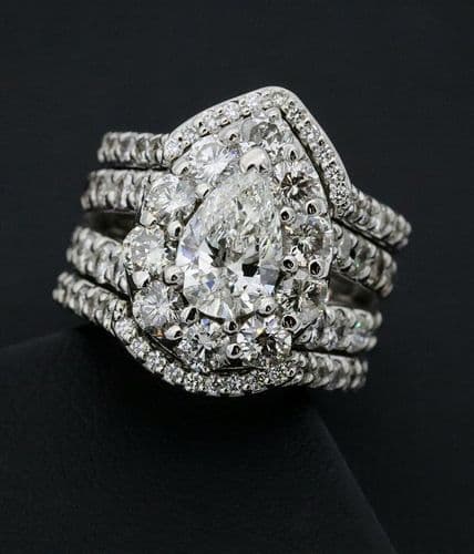 Diamond ring set with a pear-shaped center diamond and multiple pave bands.