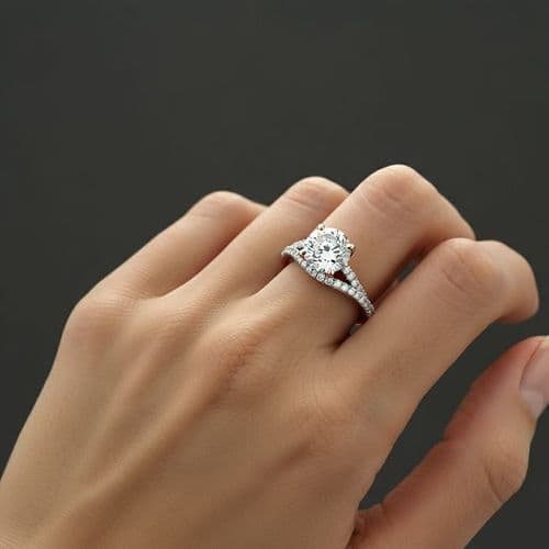 Close-up of a hand wearing an elegant diamond engagement ring with a pavé band.